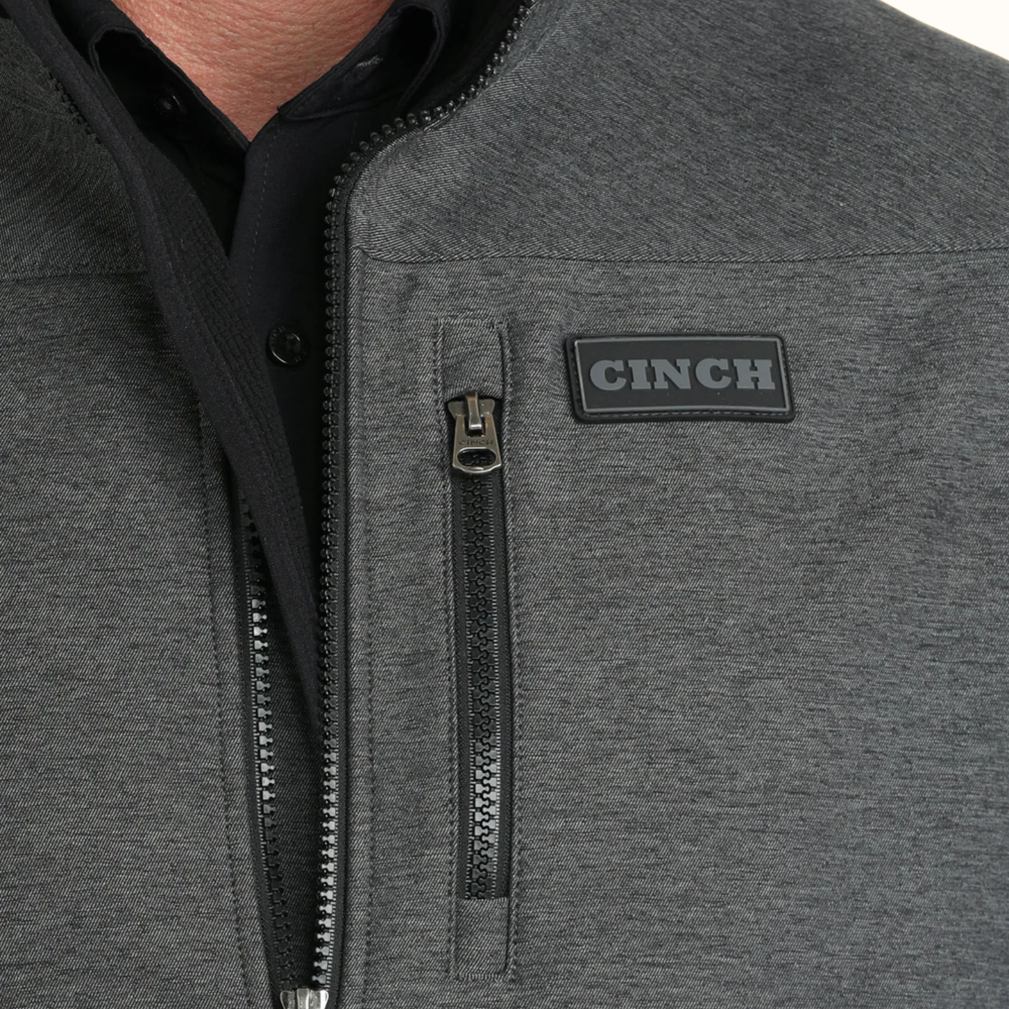 Close-up view of Cinch Men’s Bonded Vest chest logo and zipper detail