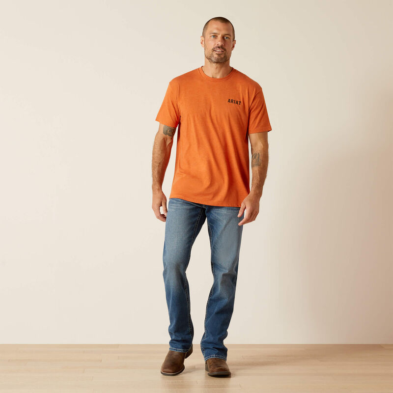 Full body view of Ariat orange Rattler Skull graphic T-shirt with jeans