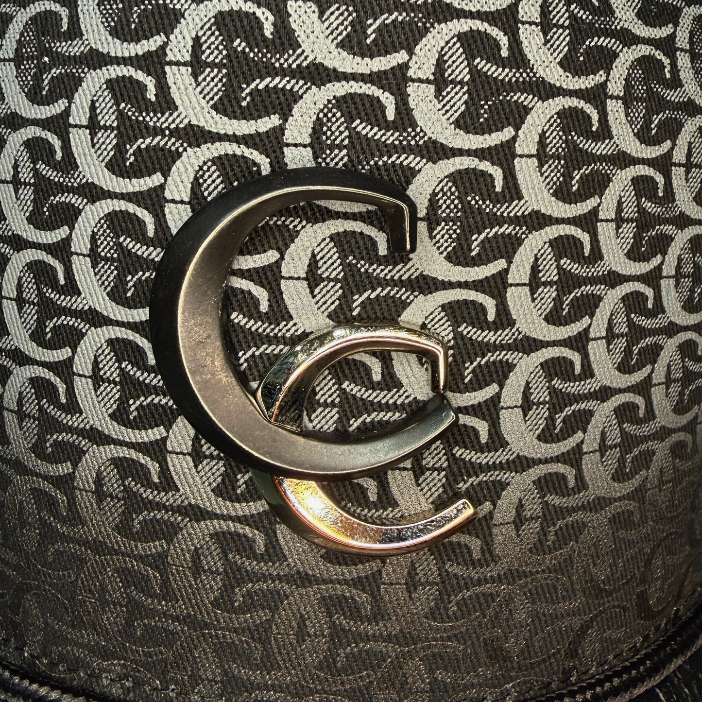 Close-up detail of black patterned fabric and Cuadra logo