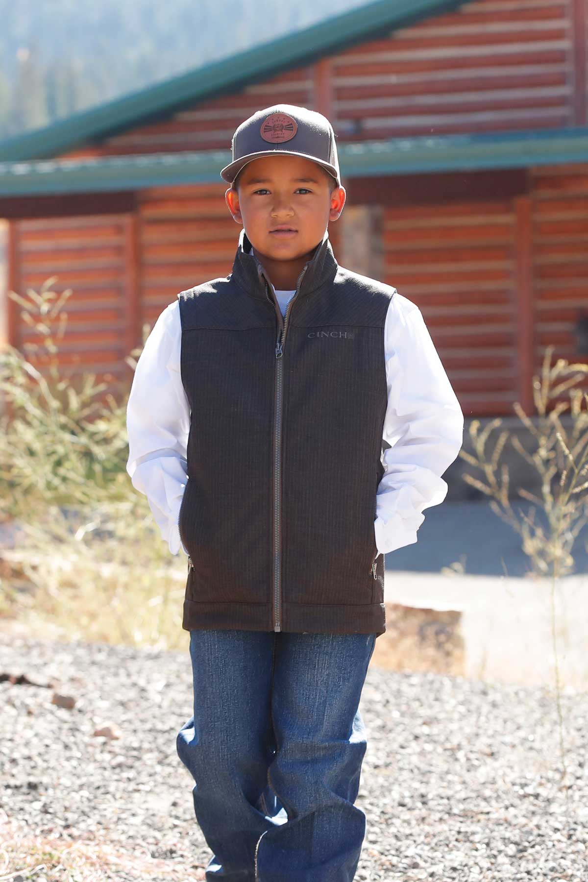 Front view of boy wearing Cinch Boys Bonded Vest in brown
