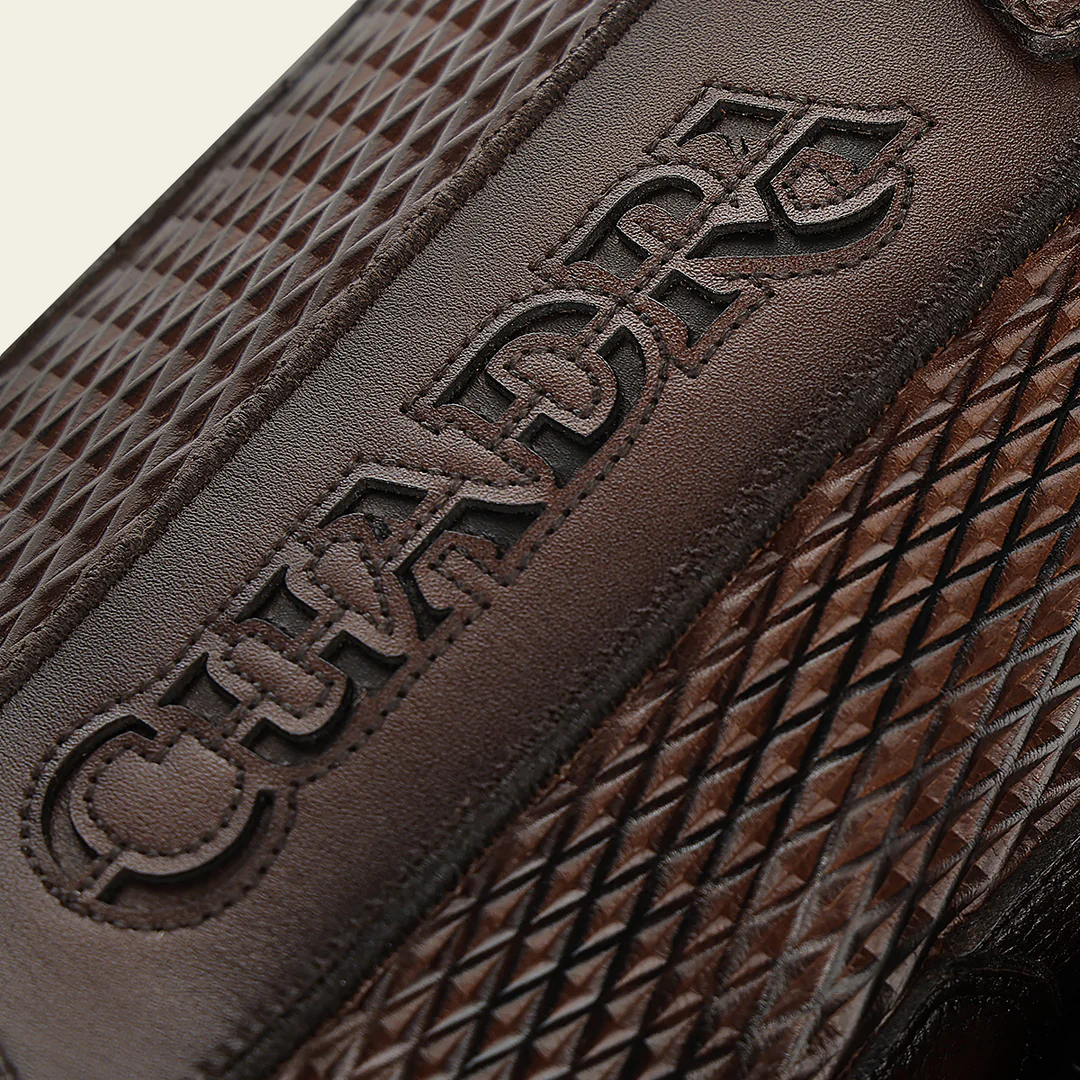 Close-up of Cuadra logo detail on honey brown leather